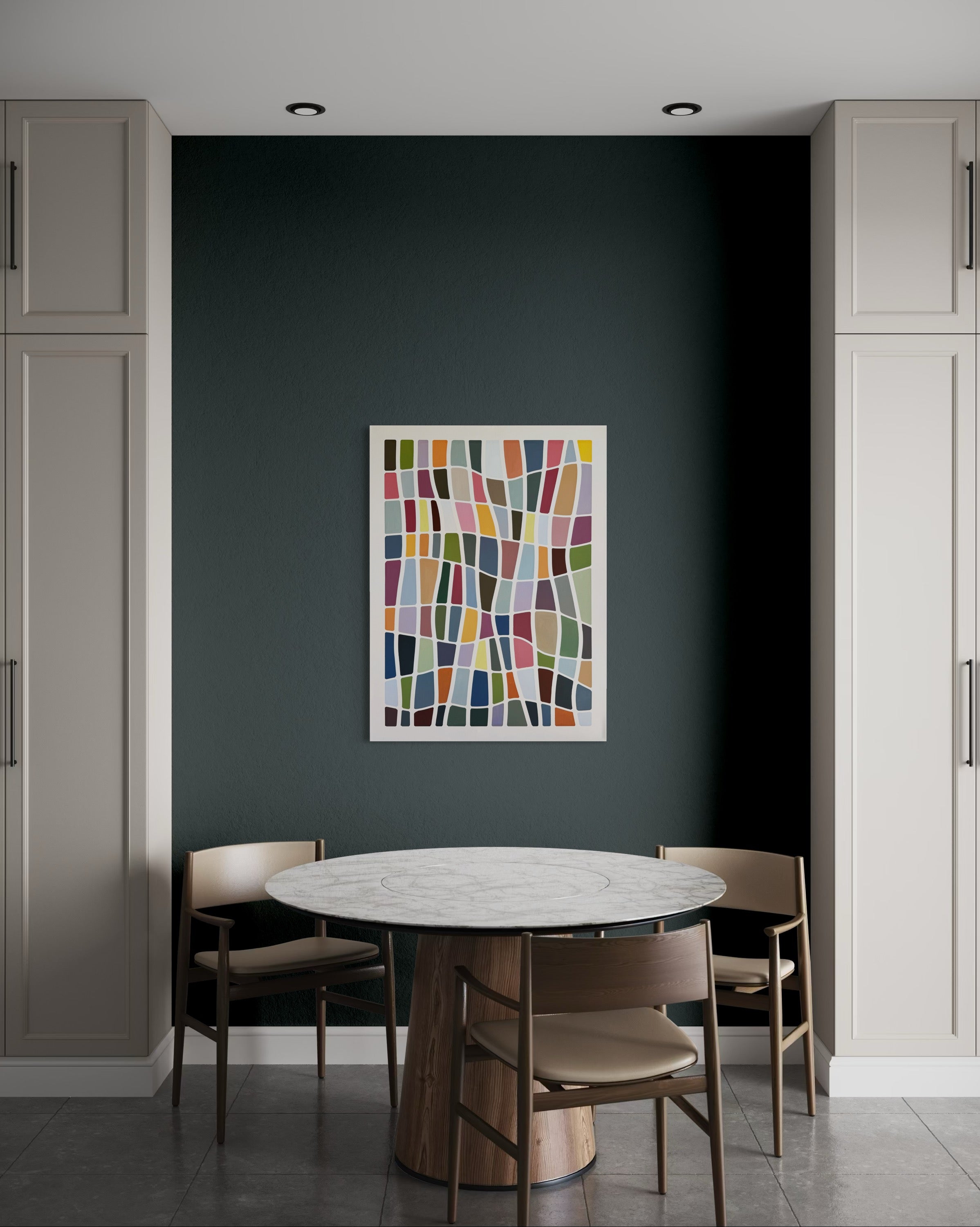 Dining area with a round table and chairs against a dark wall with a colorful abstract painting.
