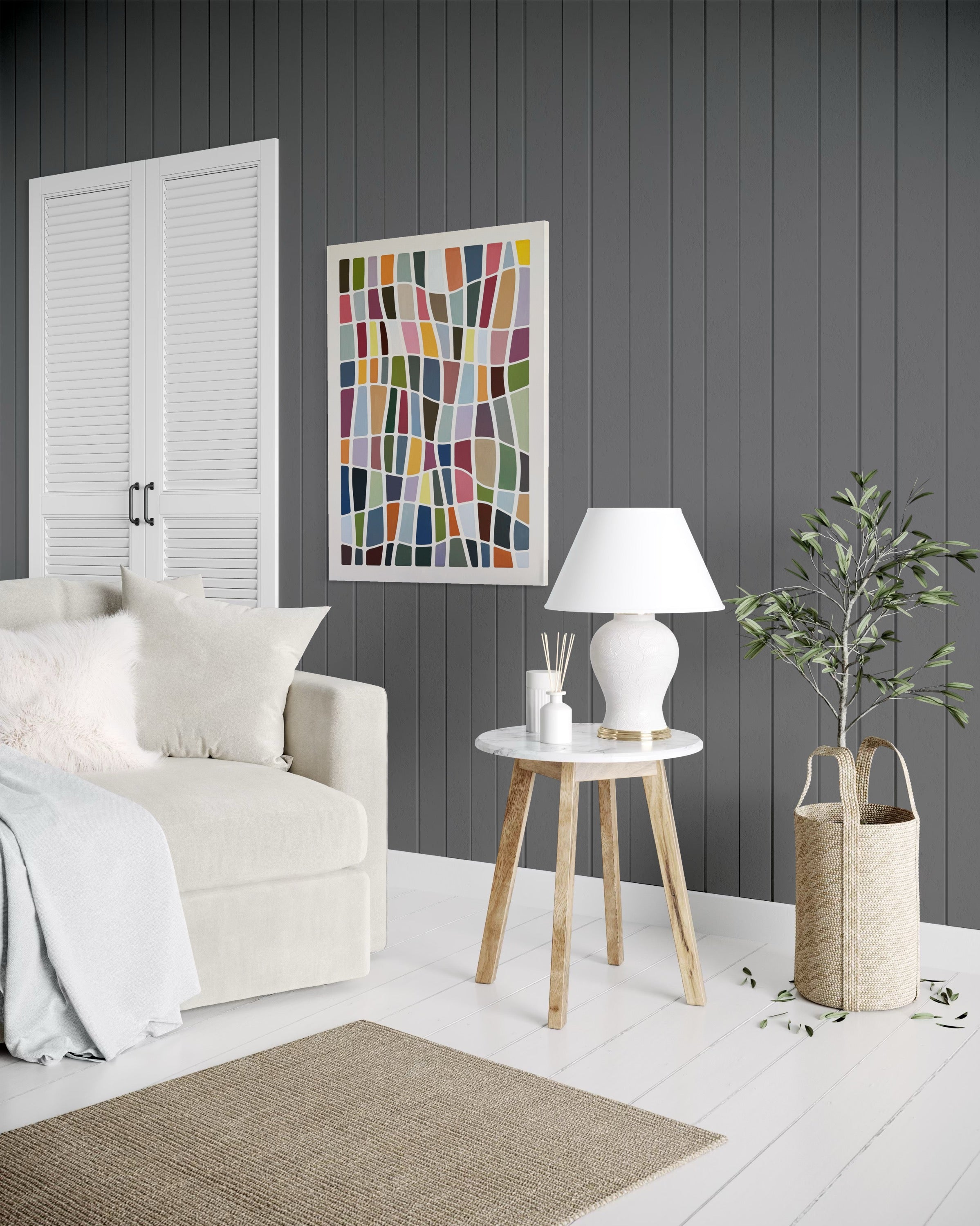 Modern living room with a white sofa, wooden side table, and abstract art on a gray wall.