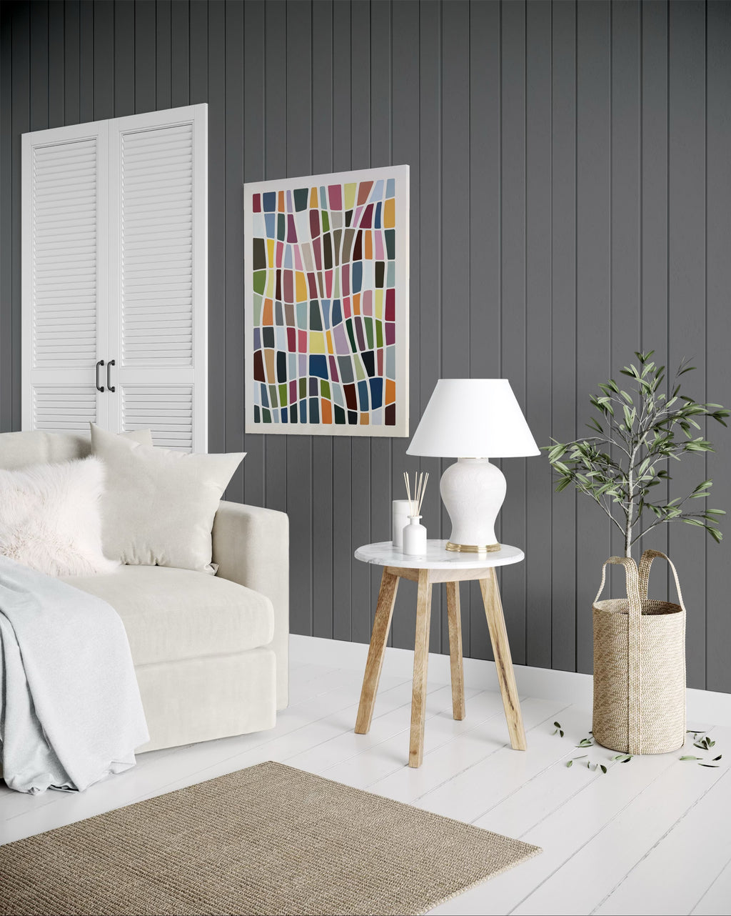 Modern living room with a white sofa, wooden side table, and abstract art on a gray wall.