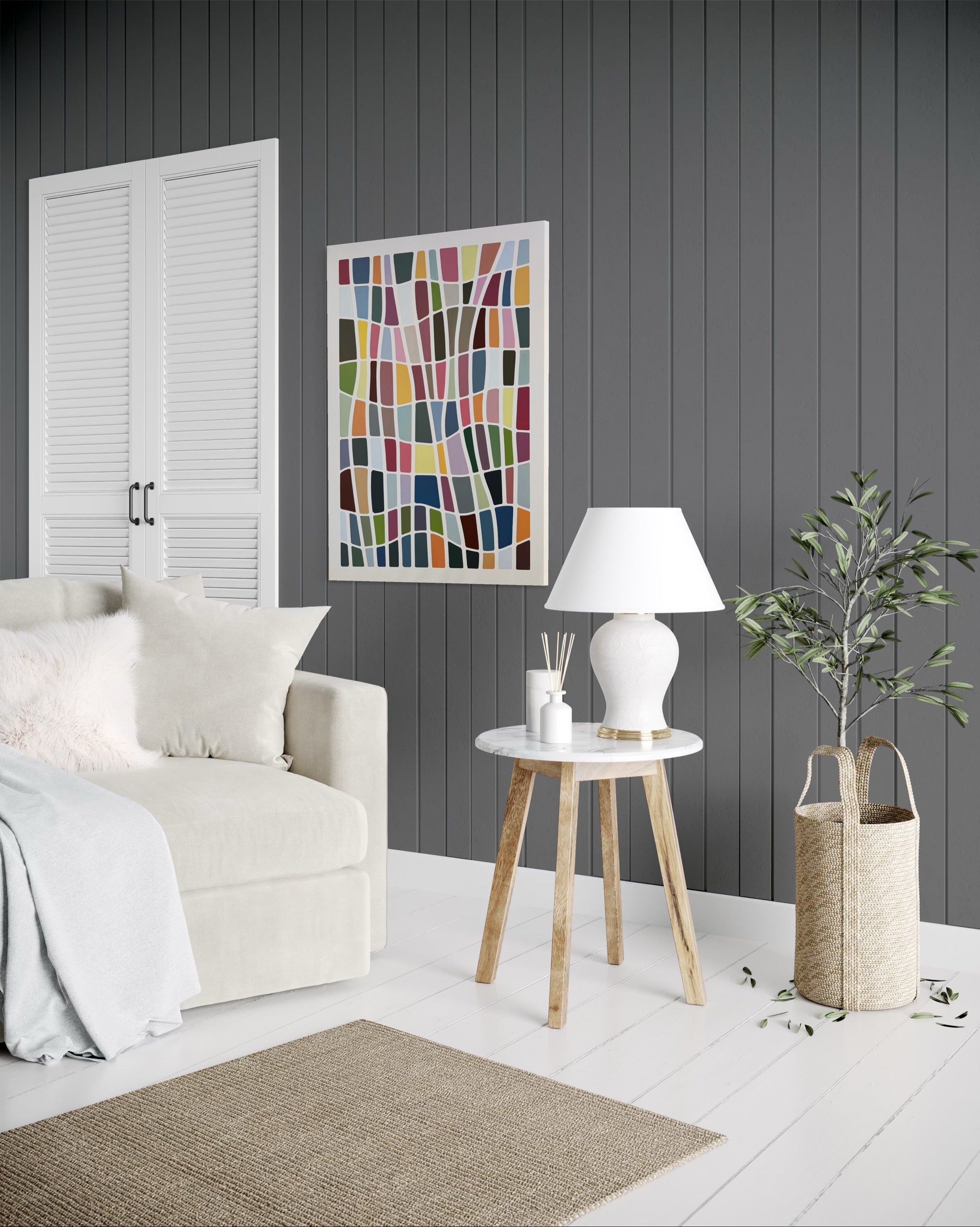 Modern living room with a white sofa, wooden side table, and abstract art on a gray wall.
