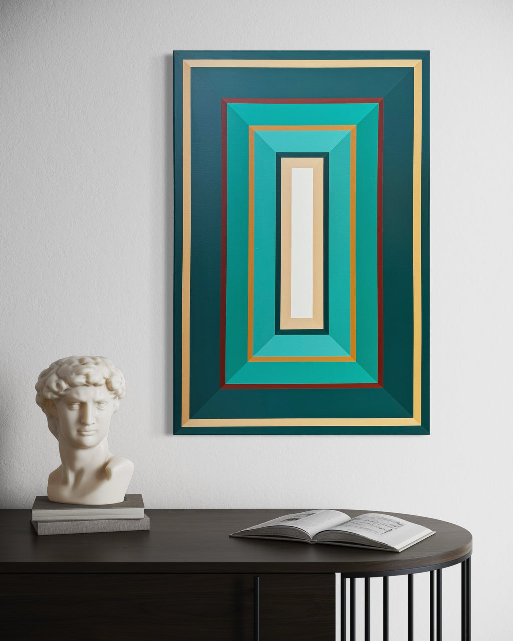 Framed abstract artwork with geometric design on a wall above a table with a sculpture and book.