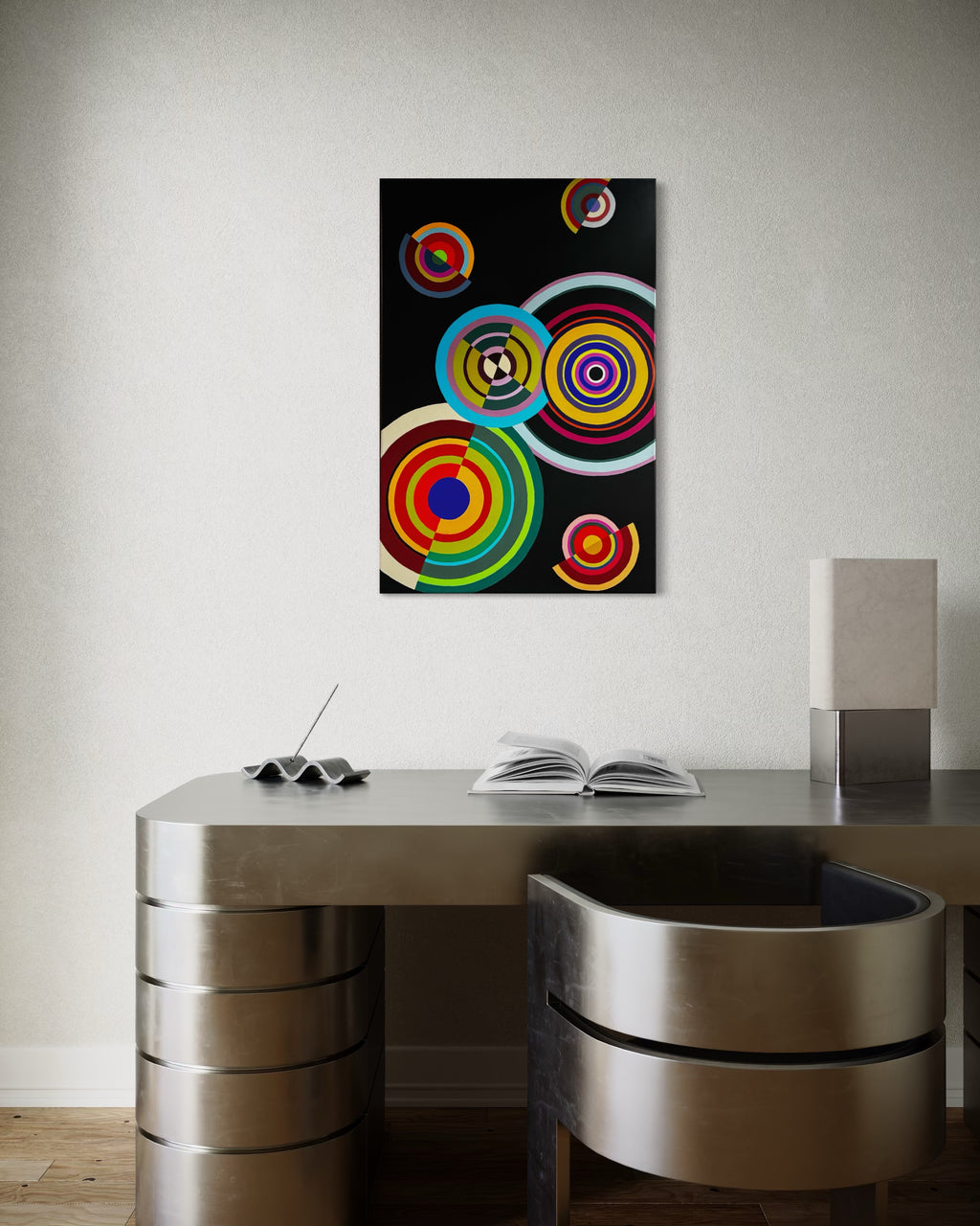 Abstract artwork with colorful circles on a black background above a modern desk.
