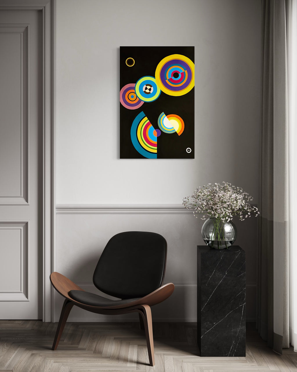 Modern interior with a colorful abstract painting on the wall, a black chair, and a small table with flowers.
