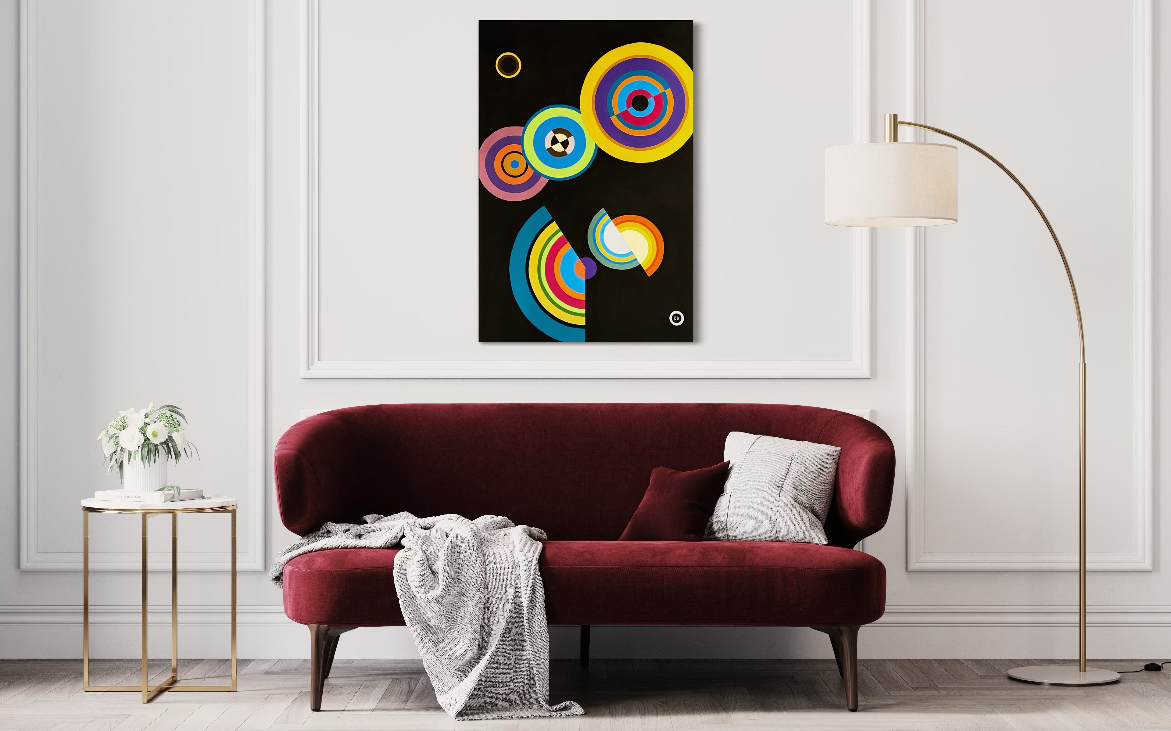 Living room with a red sofa, colorful abstract painting on the wall, and a lamp.