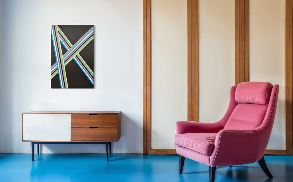 Modern interior with a pink armchair, wooden sideboard, and abstract painting on a white wall.