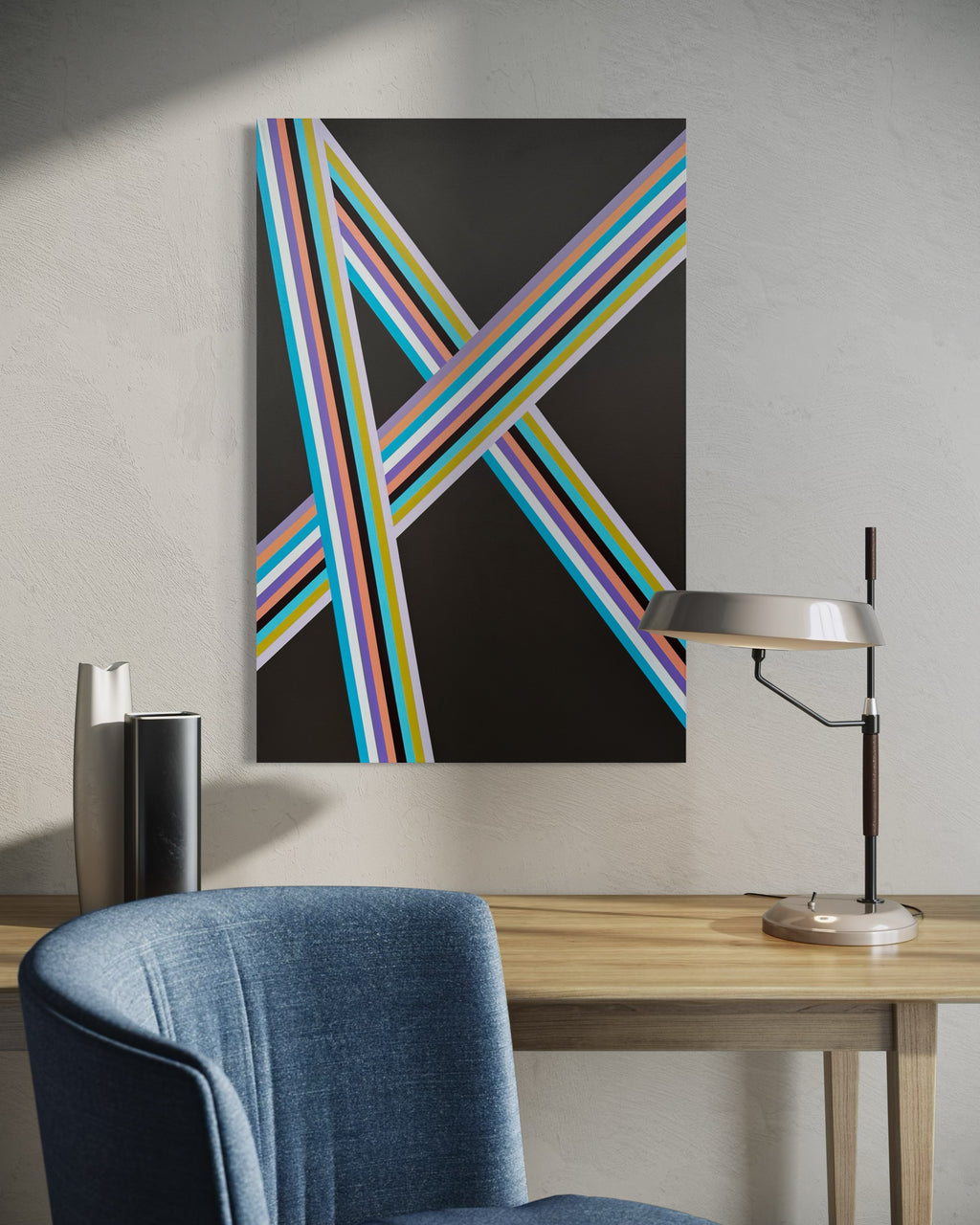 Abstract art piece with colorful stripes on a wall above a desk with a chair and lamp.