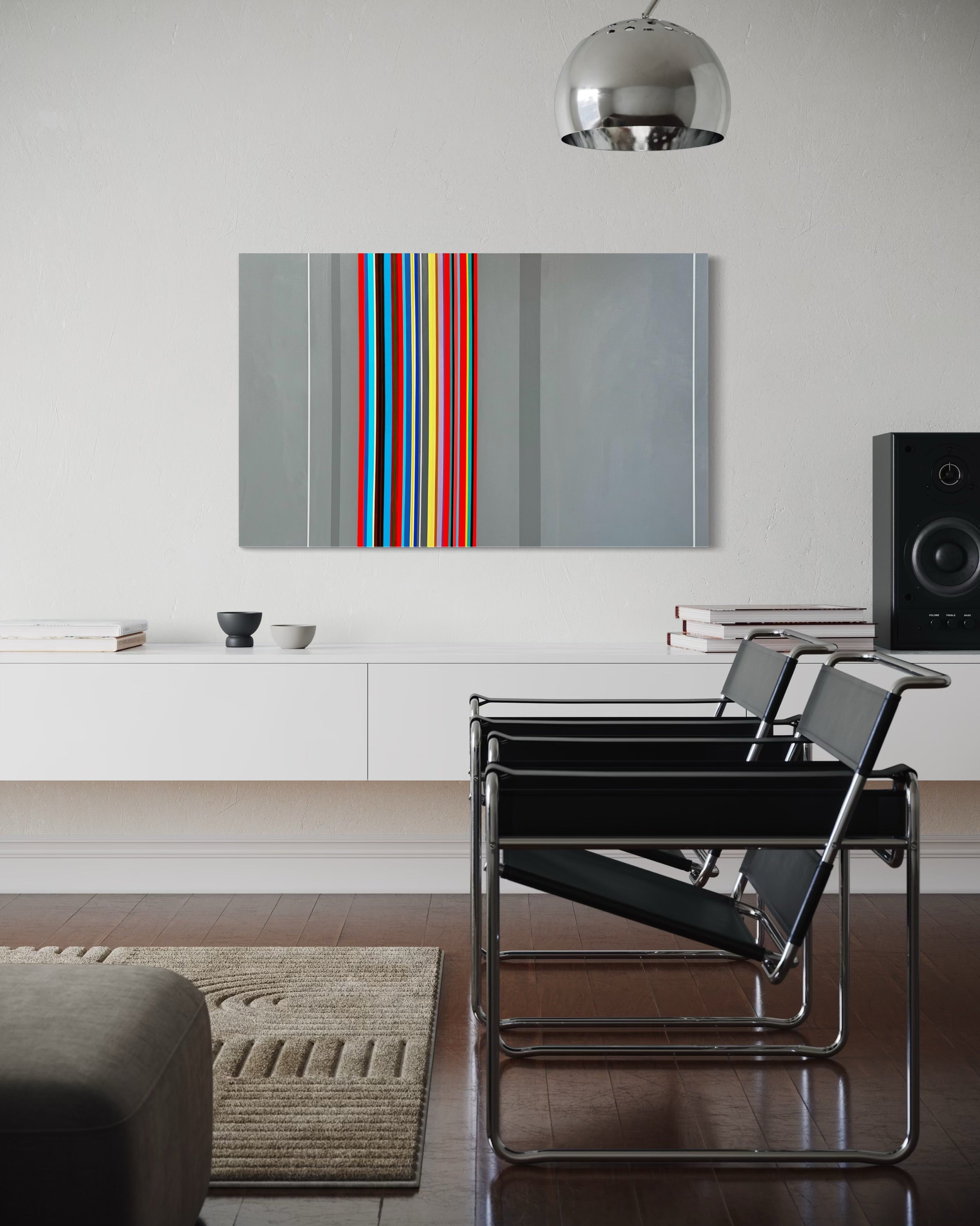 Modern living room with a colorful abstract painting, black chairs, and a silver pendant light.