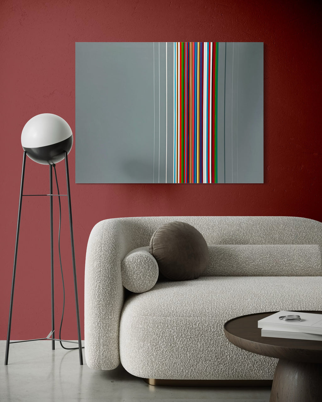 Modern living room with a gray sofa, colorful abstract painting, and a floor lamp against a red wall.