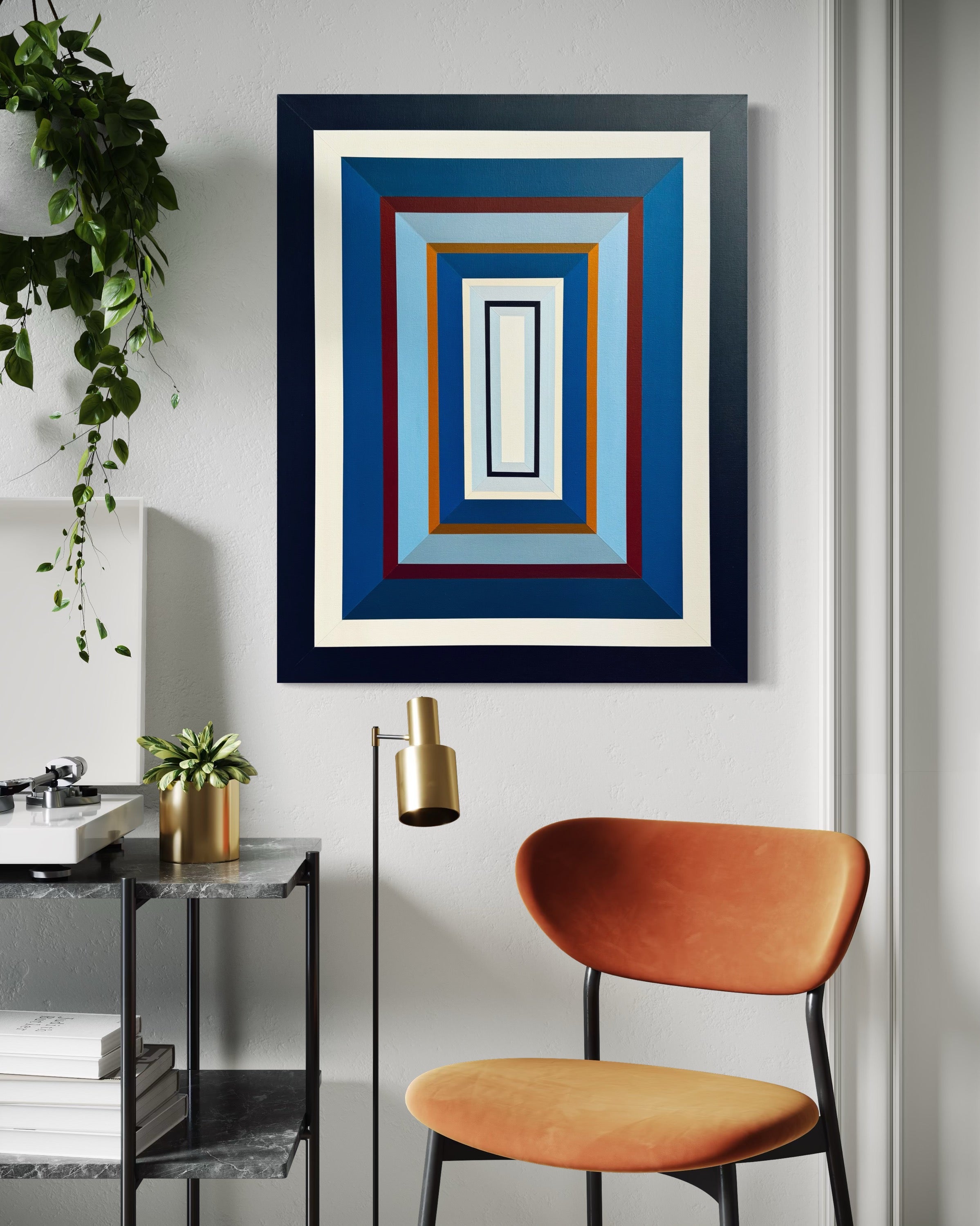 The "Denim-III" painting styled in a bright home office nook, its orange accent perfectly complementing the contemporary orange chair below.
