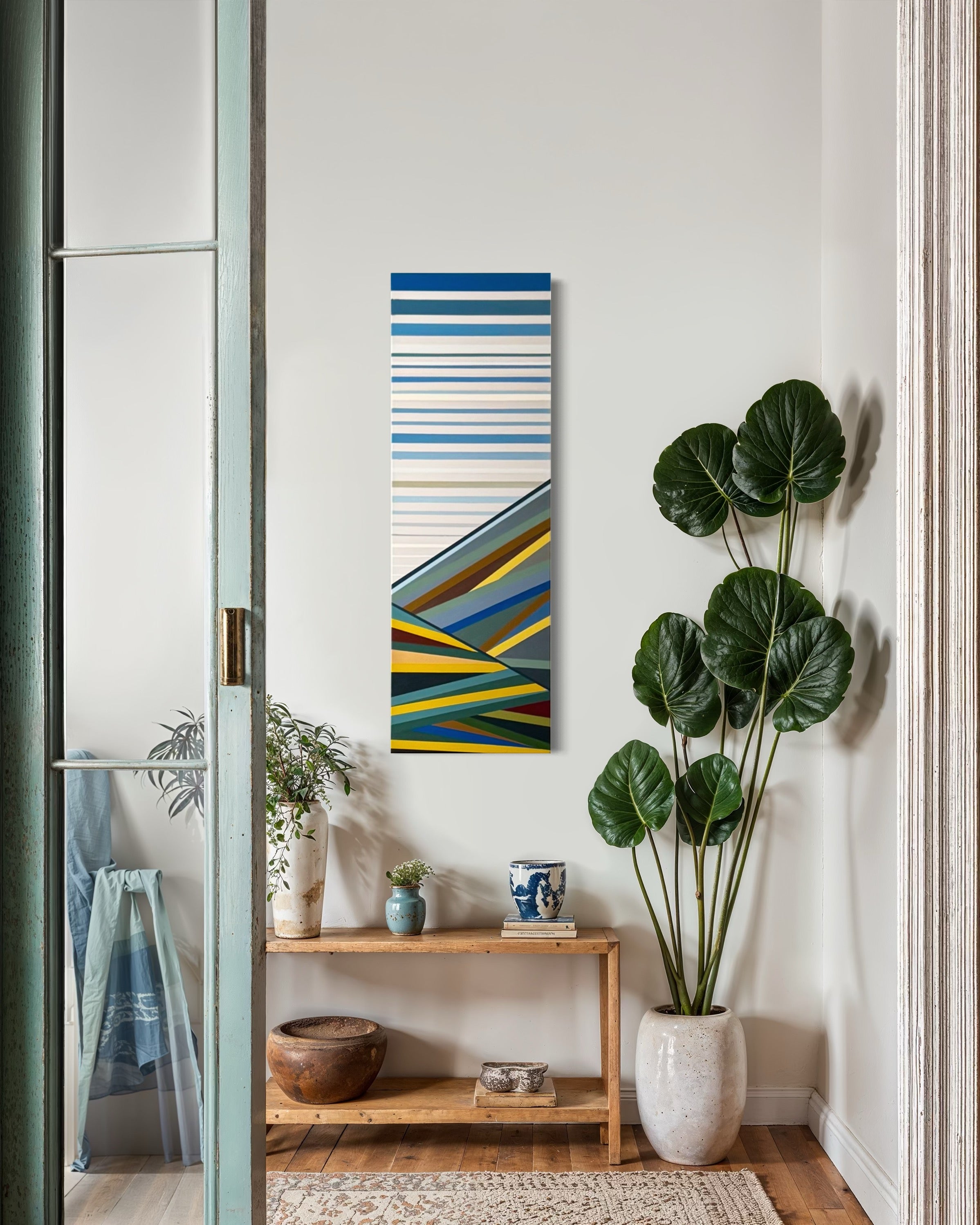 The nature-inspired colors of the "Foothills" painting harmonizing with a bright, airy room filled with large green plants and natural light.