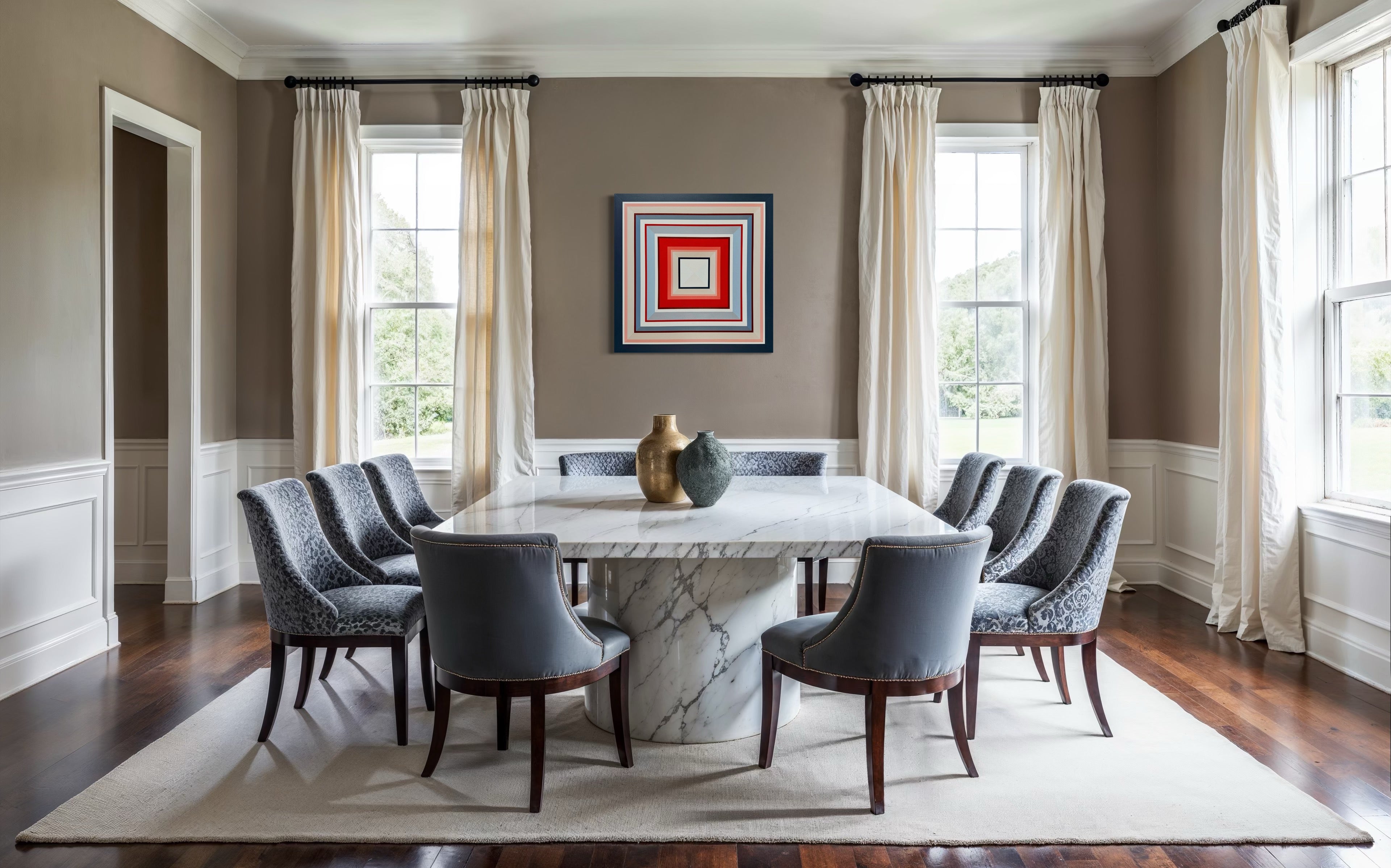 The geometric painting "In Other Words" styled as a focal point in an elegant dining room with a large marble table and grey upholstered chairs.